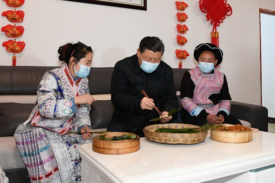 2021年2月3日下午，習近平在貴州畢節(jié)市黔西縣新仁苗族鄉(xiāng)化屋村苗族村民趙玉學家，同一家人邊聊家常邊制作當?shù)貍鹘y(tǒng)節(jié)日食品黃粑。新華社記者 李學仁 攝
